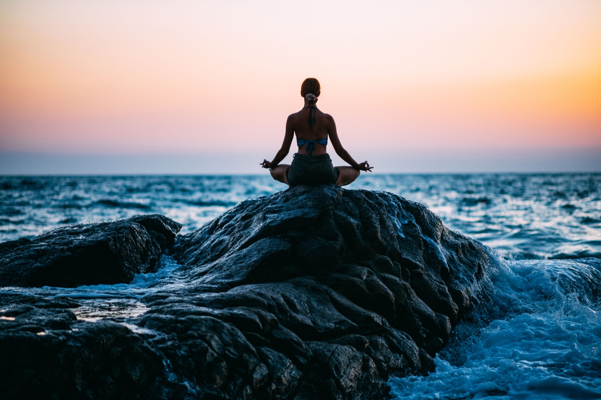 Young Woman Doing Yoga on the Beach at Sunset